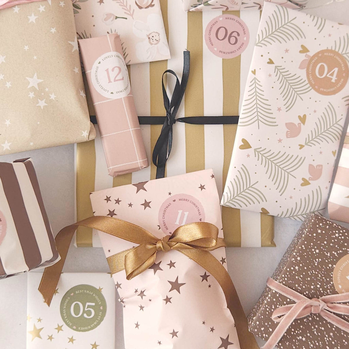 12-daagse adventskalender: bovenaanzicht van ingepakte cadeautjes met gouden en zwarte linten van CaDo Depot